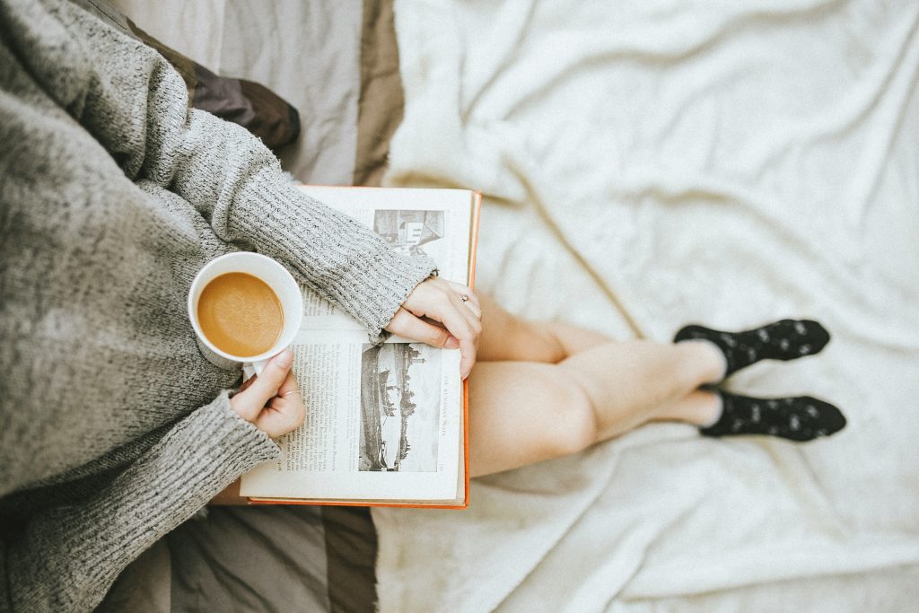 Meisje drinkt koffie en leest een boek